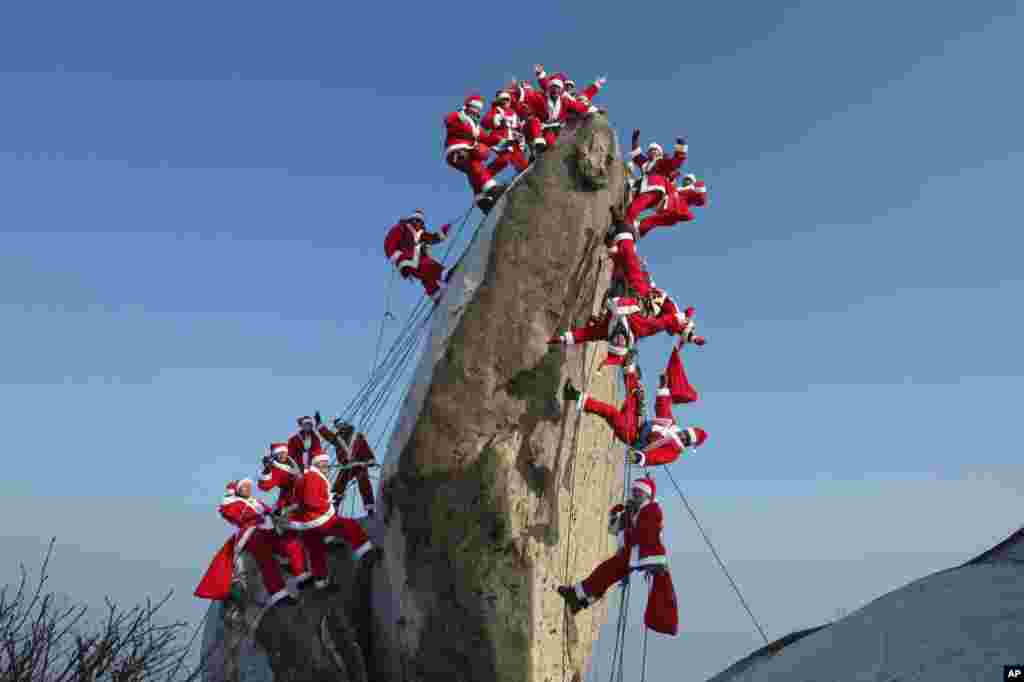 Mountain climbers in Santa Claus outfits pose during an event to hope for safe climbing and to promote Christmas charity on the Buckhan mountain in Seoul, South Korea.
