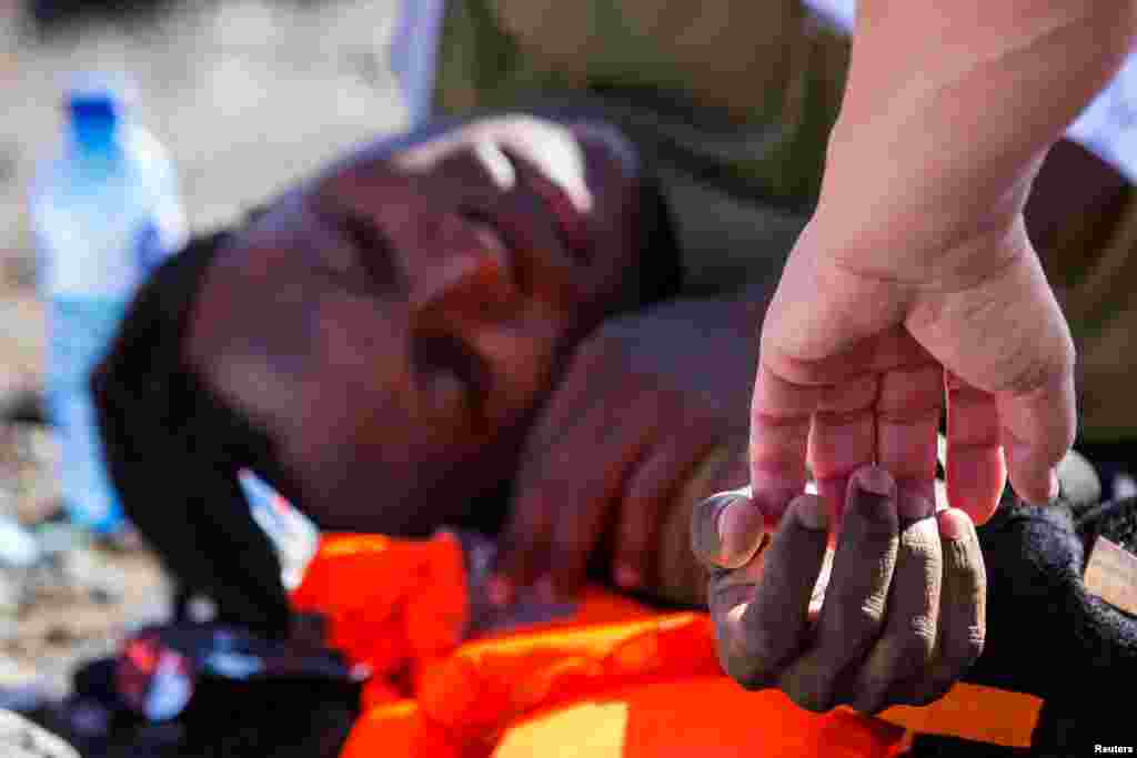 A migrant rests after landing in a dinghy on Aguila beach on the island of Gran Canaria, Spain.