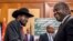FILE - South Sudan's President Salva Kiir, left, and opposition leader Riek Machar, right, shake hands during peace talks in Addis Ababa, Ethiopia, June 21, 2018.