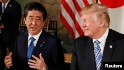 U.S. President Donald Trump looks on as Japan's Prime Minister Shinzo Abe speaks while dining at Trump's Mar-a-Lago estate in Palm Beach, April 18, 2018.
