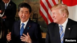 FILE - President Donald Trump looks on as Japan's Prime Minister Shinzo Abe speaks while dining at Trump's Mar-a-Lago estate in Palm Beach, April 18, 2018.