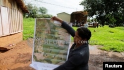 Community leader Cornelia Flores holds a map showing the community's territory which is being monitored with a smartphone app and GPS to protect lands and preserve forests, in Isla Jovai Teju, Paraguay May 9, 2019. (REUTERS/Jorge Adorno)