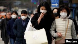 한국 서울의 거리에서 시민들이 신종 코로나바이러스 감염증(COVID-19)을 막기 위해 마스크를 착용하고 있다. 
