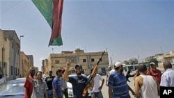 Rebel fighters gesture and flash the V-sign in the Gorgi district of Tripoli, Libya, August 23, 2011