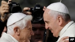 FILE—In this Sunday, Sept. 28, 2014 file photo, Pope Francis, right, hugs Emeritus Pope Benedict XVI prior to the start of a meeting with elderly faithful in St. Peter's Square at the Vatican.