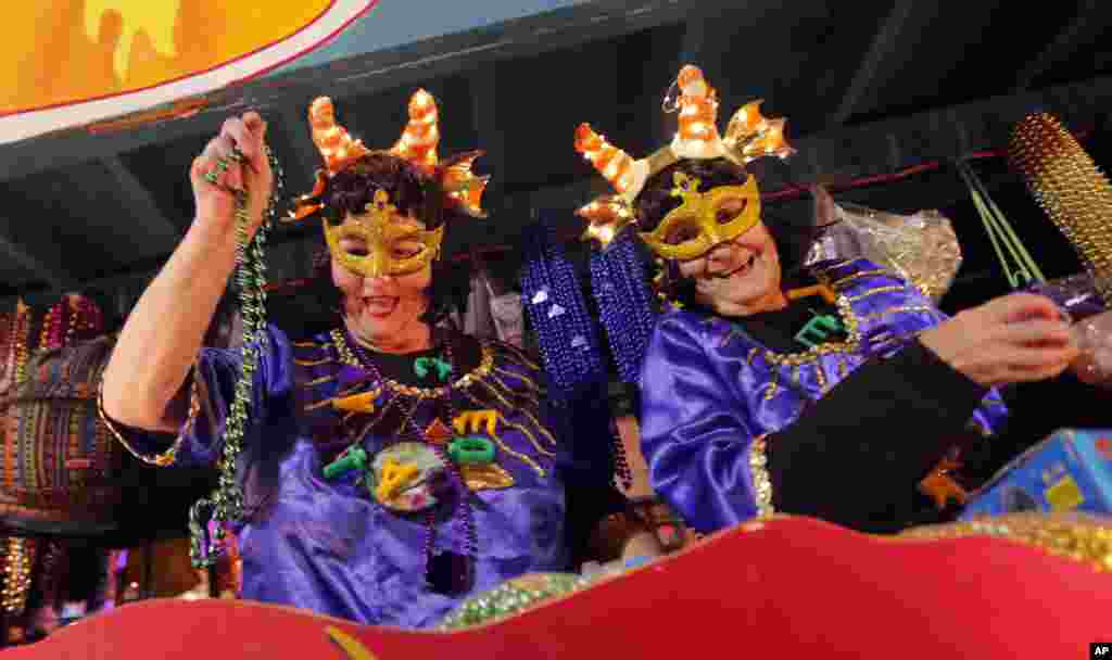 Personas en carrozas flotantes lanzan adornos durante el desfile Mardi Gras de Krewe of Cleopatra en Nueva Orleáns, el viernes 2 de febrero de 2018. Aunque la temporada de Carnaval comenzó oficialmente el 6 de enero, las festividades realmente se aceleran los dos fines de semana antes del Fat Tuesday. Este año Fat Tuesday es el 13 de febrero. (AP Photo / Gerald Herbert)