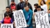 Demonstrators, holding signs with Mongolian script, protest China's changes to school curriculua that remove Mongolian language from core subjects, outside the Mongolian Ministry of Foreign Affairs in Ulaanbaatar, Mongolia, Aug. 31, 2020.