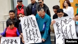 Demonstrators, holding signs with Mongolian script, protest China's changes to school curriculua that remove Mongolian language from core subjects, outside the Mongolian Ministry of Foreign Affairs in Ulaanbaatar, Mongolia, Aug. 31, 2020.