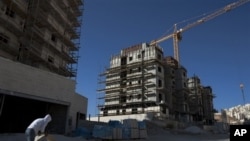 A construction worker works at a site of a new housing unit in the east Jerusalem neighborhood of Har Homa, Wednesday, Nov. 2, 2011.