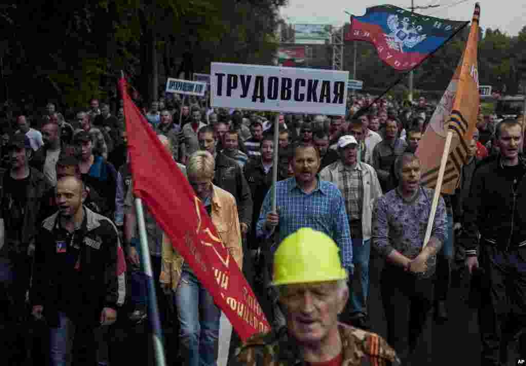 Miners, one of them carrying a sign with the name of the mine Trudovskaya, march in support of peace in Donetsk, eastern Ukraine, June 18, 2014.