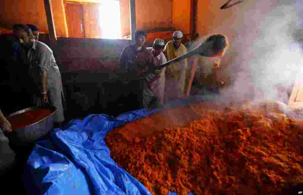 Nomadic Kashmiri Muslims prepare sweetened rice for devotees at the forest shrine of Miyan Peer, in Baba Nagri, about 44 kilometers (28 miles) northeast of Srinagar, Indian-controlled Kashmir.