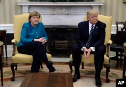 El presidente Donald Trump y la canciller alemana Angela Merkel posan para los fotógrafos en la Oficina Oval. Marzo 17, 2017.