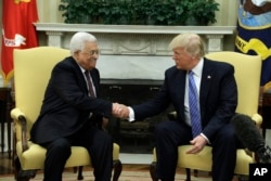 FILE - President Donald Trump shakes hands with with Palestinian leader Mahmoud Abbas during their meeting in the Oval Office of the White House, May 3, 2017, in Washington. Some Palestinian officials have described Trump as a "serious president," who is interested in a "real deal."
