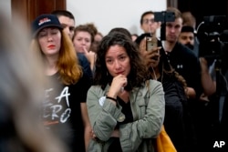 FILE - Ana Maria Archila of New York, N.Y., becomes emotional as protesters against Supreme Court nominee Brett Kavanaugh tell their personal stories of sexual assault outside offices of Sen. Jeff Flake, R-Ariz., on Capitol Hill, Sept. 24, 2018.