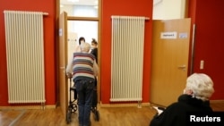 An elderly man enters a COVID-19 vaccination center temporarily set up in a former cinema in Weimar, Germany, Jan. 13, 2021. 