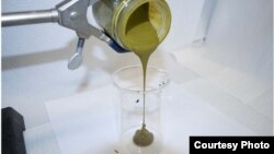 Algae slurry is seen being poured into a container. (PNNL)