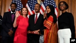 House Speaker Nancy Pelosi of Calif., second from left, poses during a ceremonial swearing-in with Rep. Ilhan Omar, D-Minn., second from right, on Capitol Hill in Washington, Jan. 3, 2019.