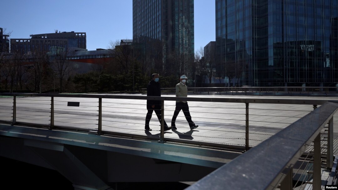 La capital japonesa anunció que el maratón de Tokio solo abrirá a atletas de élite, lo que deja fuera de la justa a cerca de 38 mil otros atletas que correrían en él. En la foto, dos personas caminan por una desolada arteria de Beijing, China, país donde se originó el virus.
