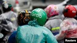 Seorang penumpang menggunakan helm Grab di Jakarta (1/2). (Reuters/Darren Whiteside)