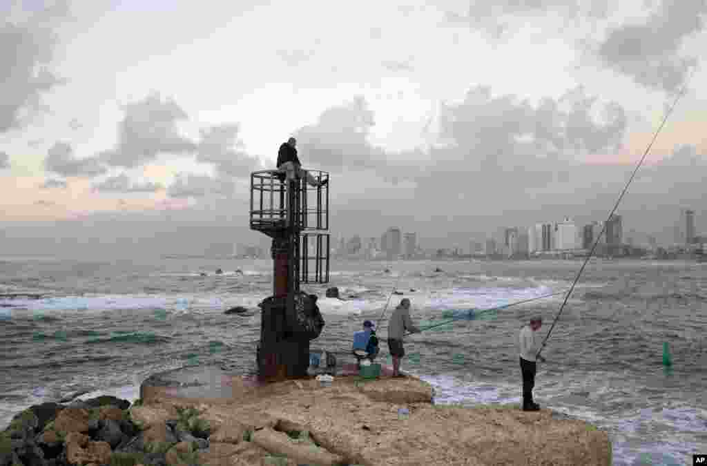 Israeli fishermen cast their rods from a pier at the the old port of Jaffa, mixed Jewish-Arab part of Tel Aviv, Israel.