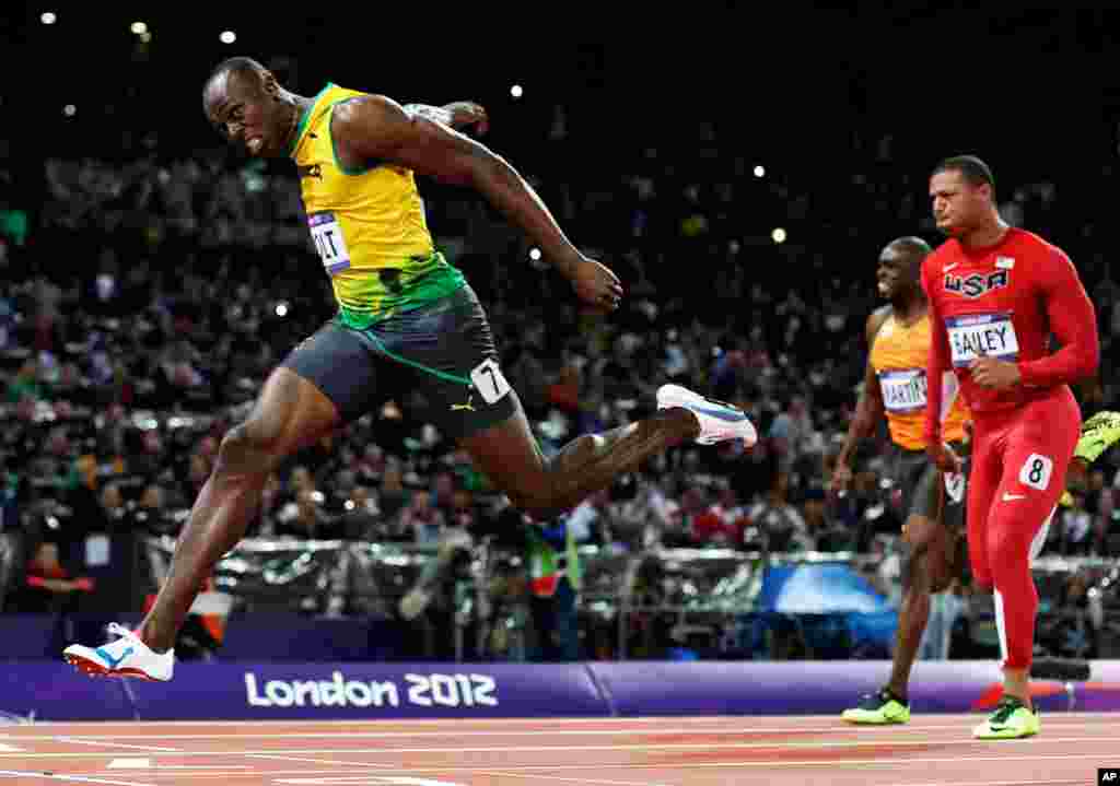 Usain Bolt dari Jamaika melintasi garis akhir untuk memenangkan medali emas dalam final lari pria 100 meter pada Olimpiade 2012 di London (5/8).