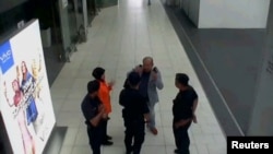 A still image from a CCTV footage appears to show a man purported to be Kim Jong Nam talking to security personnel, after being accosted by a woman in a white shirt, at Kuala Lumpur International Airport in Malaysia, Feb. 13, 2017. (FUJI TV/via Reuters)