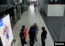FILE - A still image from a CCTV footage appears to show a man purported to be Kim Jong Nam talking to security personnel, after being accosted by a woman in a white shirt, at Kuala Lumpur International Airport in Malaysia, Feb. 13, 2017.