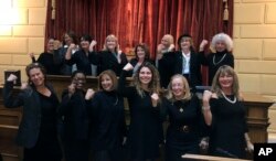 Rhode Island lawmakers wear black to in solidarity with the Time's Up movement and as a statement against sexual misconduct stand, at the House speaker's rostrum at the Statehouse in Providence, Rhode Island Jan. 9, 2018.