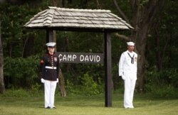 FILE - Members of an honor guard stand at attention at Camp David, Md.