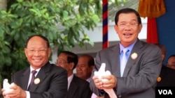 Heng Samrin, National Assembly President and Prime Minister Hun Sen, about to release doves during the 65th annual celebration of ruling party Cambodian People's Party (CPP) establishment on Tuesday, June 28, 2016 at CPP's headquarter in Phnom Penh. (Photo: Leng Len/VOA Khmer)