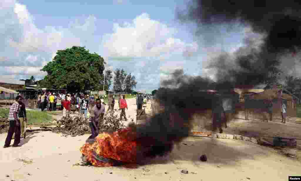 Residents make a bonfire to barricade a main road as they protest after gunmen attacked the coastal Kenyan town of Mpeketoni, June 17, 2014.