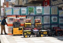 FILE - Air conditioners and power generators are displayed on a street in central Baghdad, Iraq, July 30, 2015. Eliminating hydrofluorocarbons, found in cooling systems, would avoid half a degree Celsius of global warming worldwide.