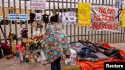 Migrantes duermen cerca de un altar en el eterior del centro de detención de migrantes de Ciudad Juárez, México, donde perecieron 40 personas en un incendio, el 30 de marzo de 2023.