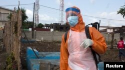 FILE - A health worker prepares to disinfect a van used for burial purposes in Freetown, Sierra Leone.