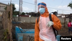 A health worker prepares to disinfect a van used for burial purposes in Freetown, Sierra Leone, Nov. 10, 2014. 