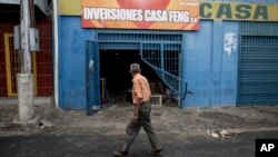 A man walks past a looted grocery store in Ciudad Bolivar, Venezuela, Dec. 19, 2016.