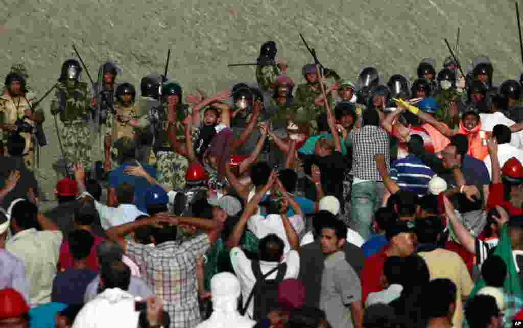 Protesters shout as security forces with armoured vehicles push protesters away from Abbasiya square near the Defense Ministry. (Reuters)