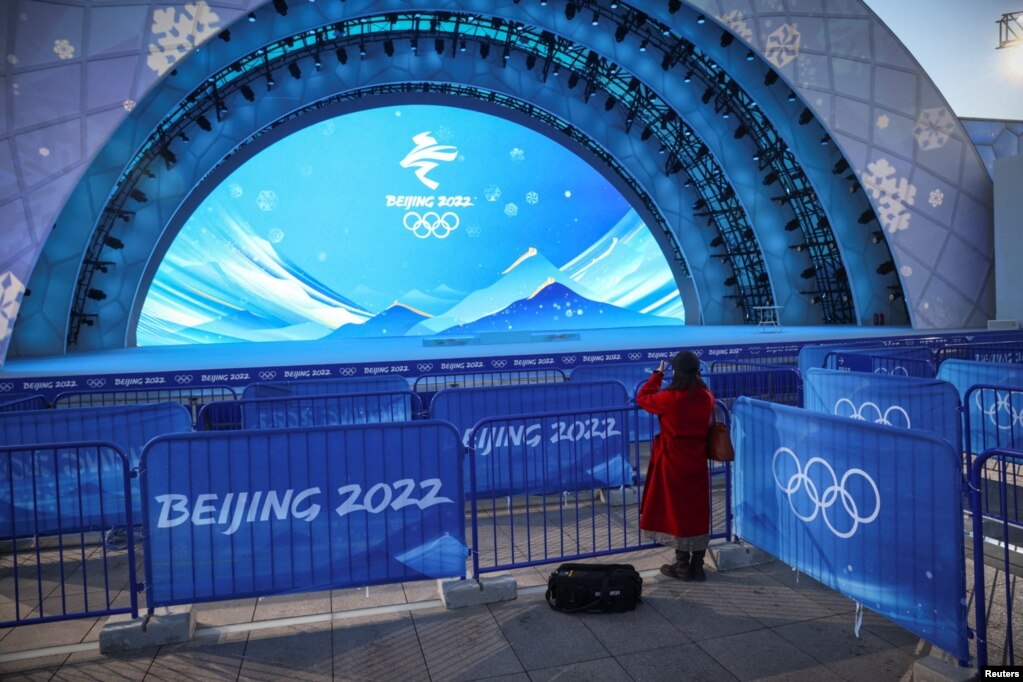 一名女子在给北京冬奥会设立的颁奖台拍摄照片。（2022年1月3日）(photo:VOA)