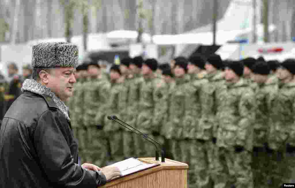 Ukraine&#39;s President Petro Poroshenko delivers a speech during his visit to the training center of the Ukrainian National Guard outside Kyiv, in this handout picture. Poroshenko said the country is still a long way from peace and that there are no guarantees a ceasefire deal agreed upon in Belarus Thursday would take effect.