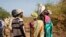 In this photo taken Dec. 7, 2018, women speak to members of a UN peacekeeping patrol as they walk to get food in Bentiu, a 38 kilometers (24 mile) journey where there are fears of being attacked on the main road, from Nhialdu in South Sudan. 