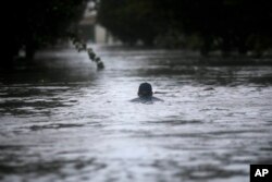 Una cubana nada en una calle inundada de La Habana tras el paso del huracán Irma por Cuba. Sept. 10, 2017.