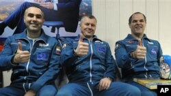 Kosmonot Rusia Yevgeny Tarelkin (kiri), Oleg Novitsky (tengah) dan astronot NASA Kevin Ford berpose di bandara Kostanai, Kazakhstan seusai pendaratan dengan kapsul Soyuz (16/3).