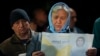 A woman looks at a paper promoting Moldova's President Maia Sandu in Magdacesti, Moldova, Oct. 17, 2024, ahead of a presidential election and a referendum on whether to enshrine in Moldova's Constitution its path to European Union membership.