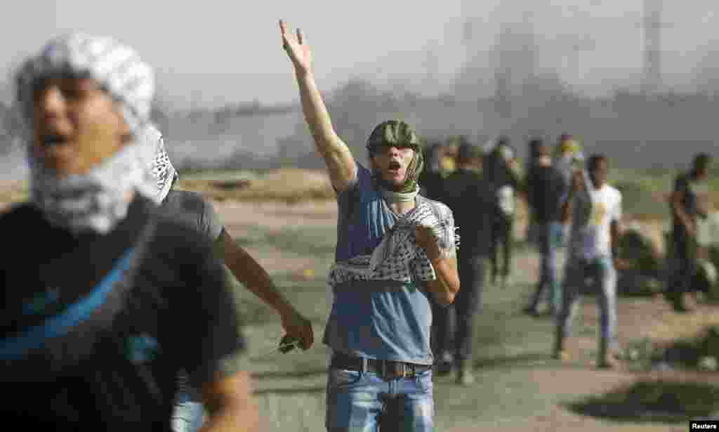 فلسطینی مظاہرین اسرائیلی فورسز سے جھڑپ کے دوران پتھر پھینکے رہے ہیں۔