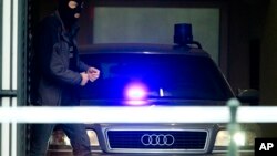 A Belgian policeman leaves a court building with a vehicle believed to be transporting Salah Abdeslam, the top suspect in last year's deadly Paris attacks, who appeared before a judge in Brussels, Belgium, March 24, 2016. 