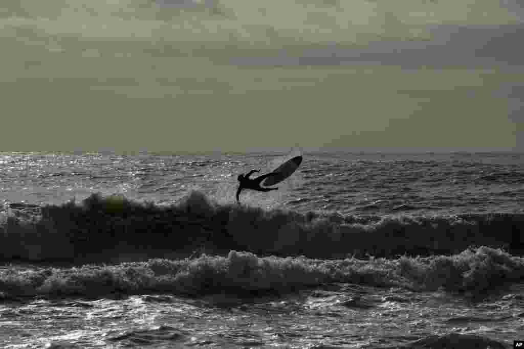 A surfer rides a wave at Rome&#39;s Ostia beach, Italy.