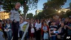 FILE - In this Jan. 21, 2015, photo, people wait their turn to enter the U.S. Interests Section to apply for U.S. travel visas, in Havana, Cuba. The U.S. State Department said March, 15, 2019, that it is eliminating a coveted five-year tourist visa. 