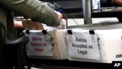 30일 마이애미 데이드 카운티 선거 사무소의 직원이 8월 예비 선거 우편투표용지를 '합법'과 '불법' 함에 분리하고 있다. 