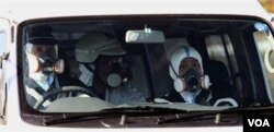 Polisi di Fukushima mengenakan masker saat berpatroli, Sabtu (12/3).
