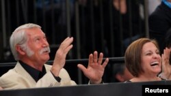 FILE - Mary Lou Retton, right, and her former coach Bela Karolyi laugh as they sit next to the floor during the AT&T American Cup gymnastics competition at New York's Madison Square Garden March 3, 2012.